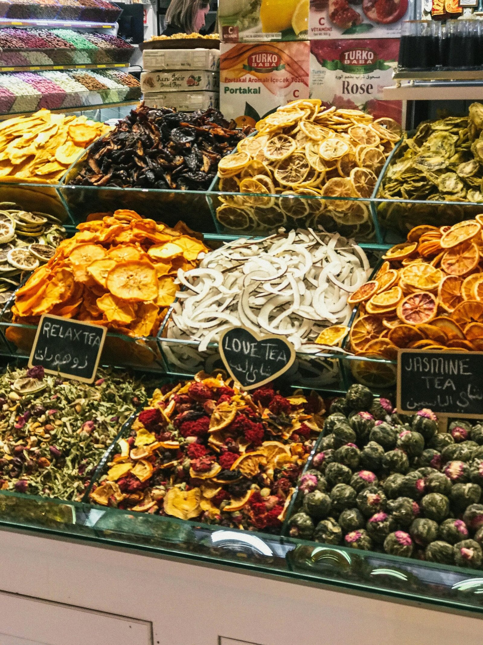 Colorful assortment of dried fruits and specialty teas in a market setting, showcasing flavors and textures.