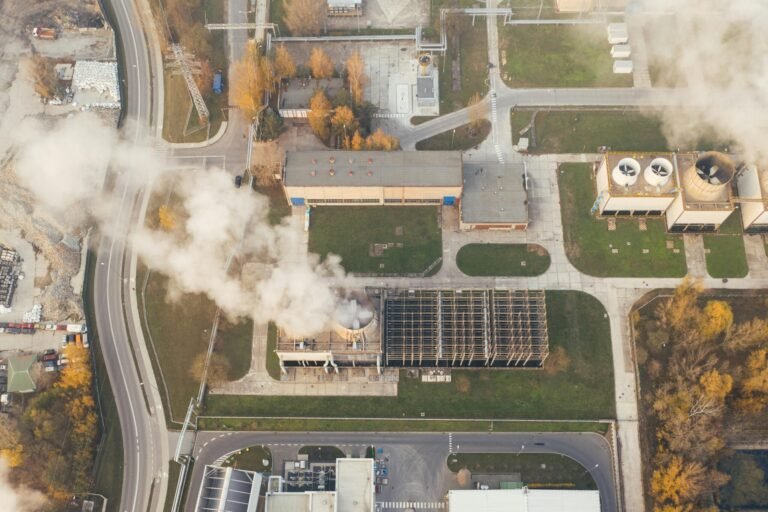 Aerial shot of an industrial area with visible smoke emissions in Poznań, Poland.