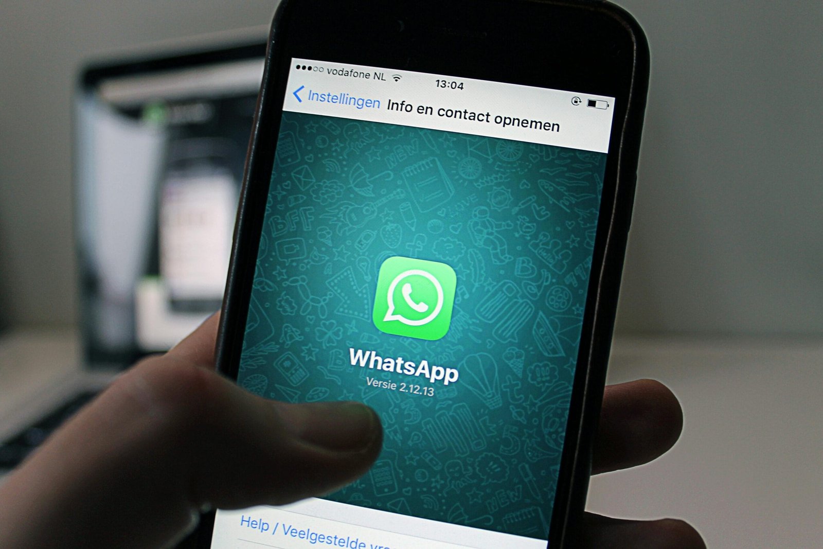 A smartphone displaying the WhatsApp application screen held by a person.