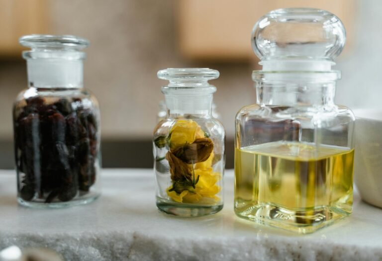 Glass bottles with natural ingredients for aromatherapy on a marble surface. Ideal for wellness themes.